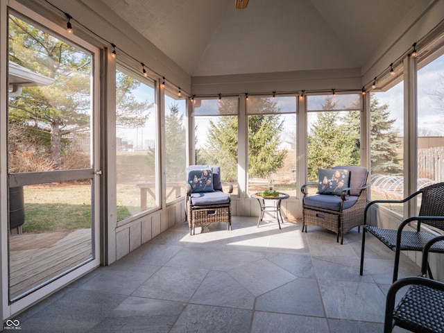 sunroom featuring lofted ceiling and a healthy amount of sunlight