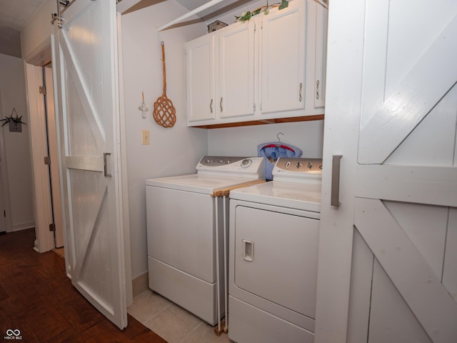 laundry room with washing machine and dryer, cabinet space, and a barn door