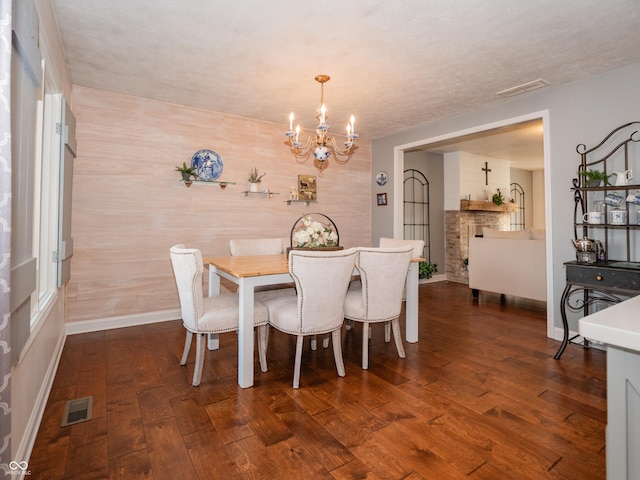 dining area featuring baseboards, a notable chandelier, visible vents, and hardwood / wood-style floors