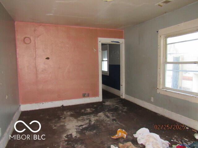 empty room featuring visible vents, plenty of natural light, and baseboards