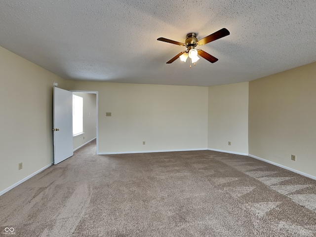 empty room with a ceiling fan, carpet, a textured ceiling, and baseboards