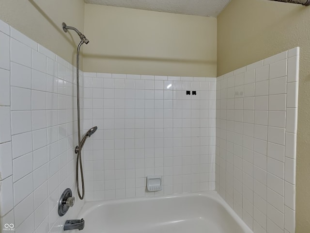 bathroom featuring bathtub / shower combination and a textured ceiling