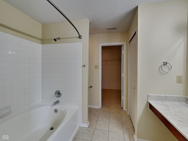 full bathroom with shower / bath combination, visible vents, a spacious closet, a textured ceiling, and tile patterned floors