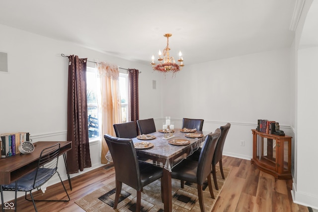 dining room featuring a notable chandelier, baseboards, and light wood-style floors