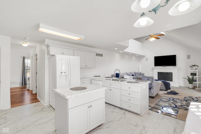 kitchen featuring visible vents, a center island, light countertops, marble finish floor, and a sink