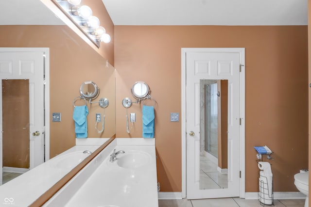 bathroom with tile patterned flooring, toilet, vanity, and baseboards