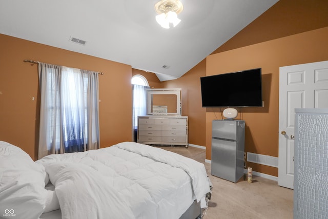 bedroom featuring visible vents, baseboards, lofted ceiling, freestanding refrigerator, and light colored carpet