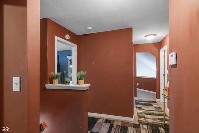 corridor with baseboards and a textured ceiling