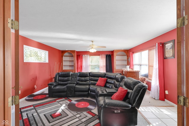 living area with baseboards, a healthy amount of sunlight, and ceiling fan