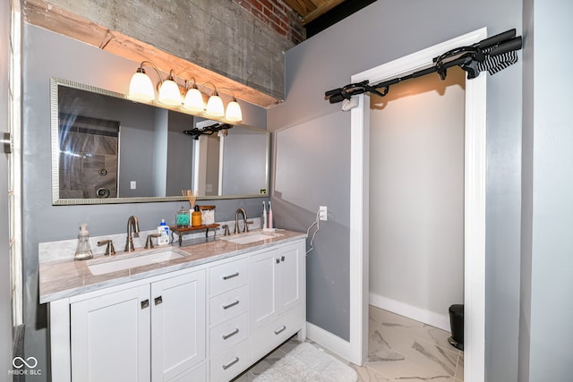 bathroom with marble finish floor, a sink, baseboards, and double vanity