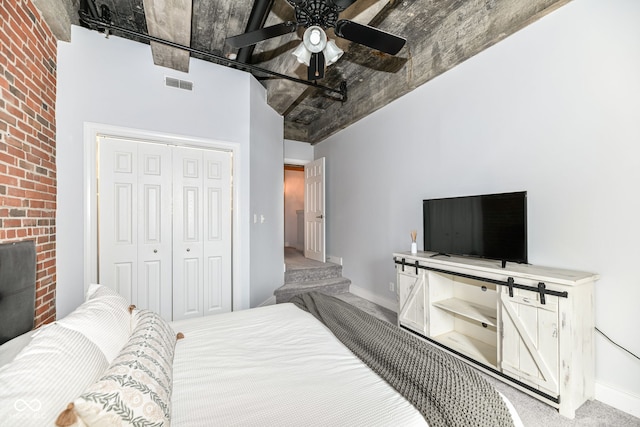 carpeted bedroom with a ceiling fan, baseboards, visible vents, and a closet