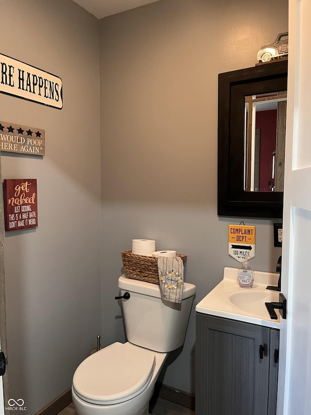 half bathroom featuring vanity and toilet