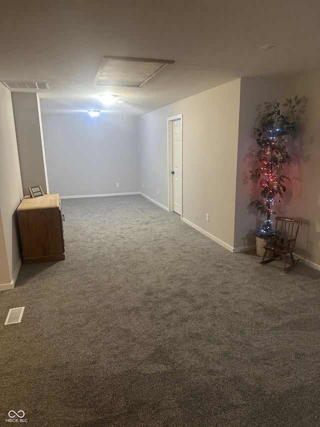 basement featuring carpet, visible vents, and baseboards