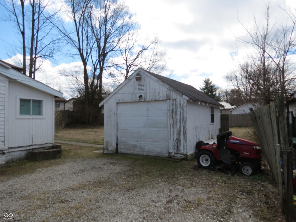 detached garage with driveway and fence