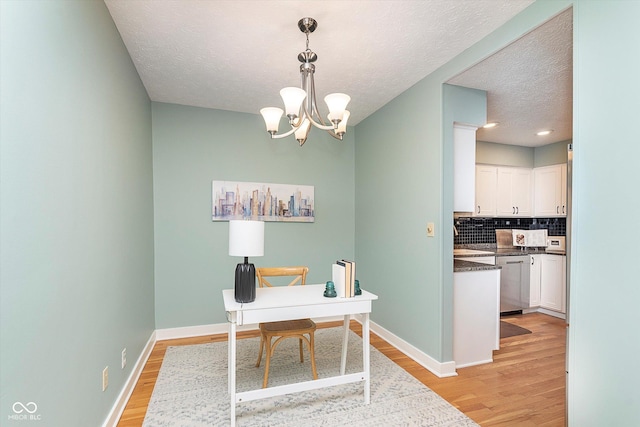 office area featuring a chandelier, light wood-style flooring, and baseboards