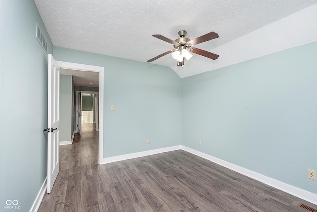 spare room featuring baseboards, a textured ceiling, visible vents, and dark wood-style flooring