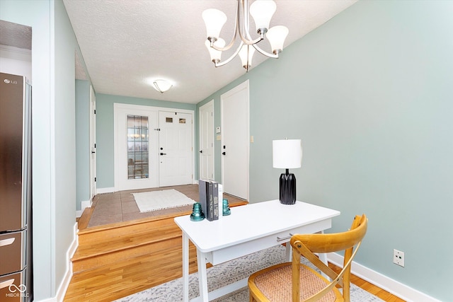 home office featuring a notable chandelier, a textured ceiling, baseboards, and wood finished floors