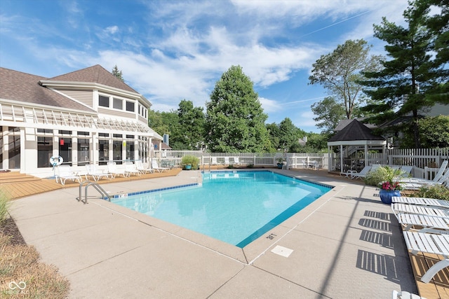 pool with a gazebo, a patio, and fence