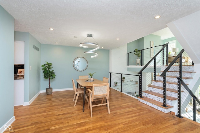 dining room featuring recessed lighting, baseboards, visible vents, and light wood finished floors