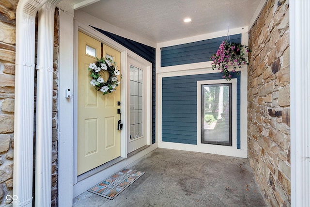 entrance to property with covered porch and stone siding