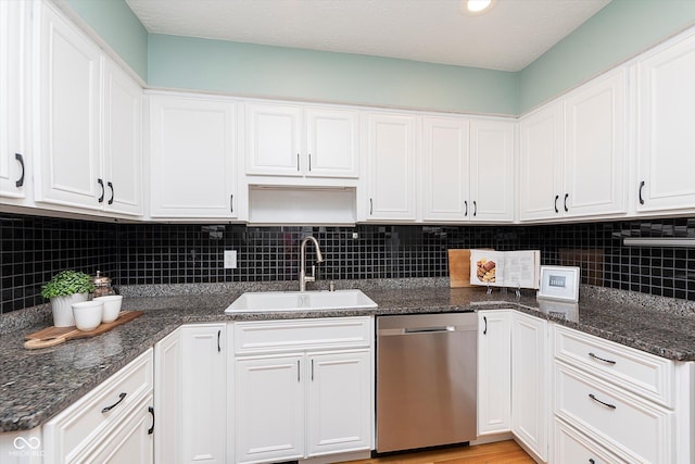 kitchen with dishwasher, a sink, and white cabinets