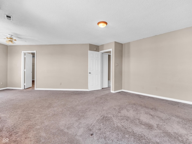 carpeted empty room with visible vents, ceiling fan, a textured ceiling, and baseboards