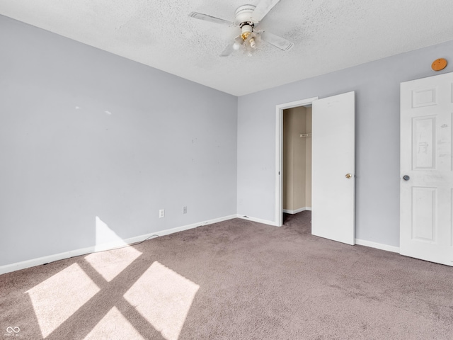 unfurnished bedroom featuring a textured ceiling, carpet floors, ceiling fan, and baseboards