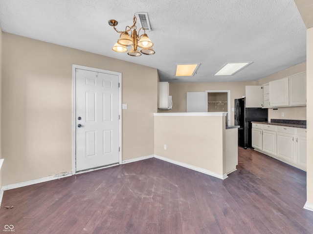 kitchen featuring dark wood-style floors, baseboards, visible vents, and white cabinetry