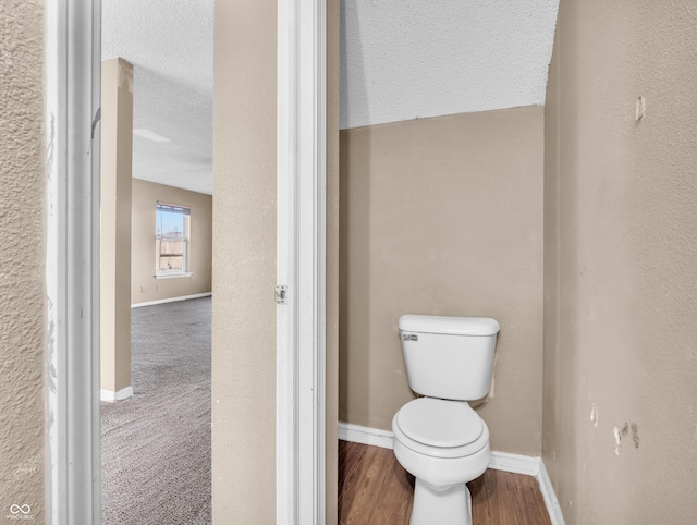 bathroom with wood finished floors, toilet, and baseboards