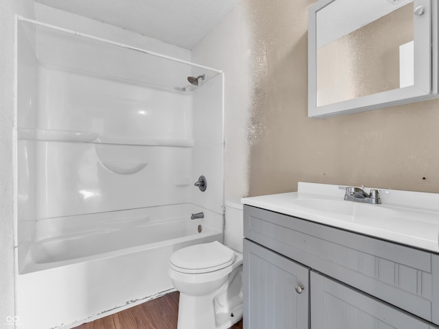 full bathroom featuring toilet, wood finished floors, a textured ceiling, vanity, and shower / washtub combination