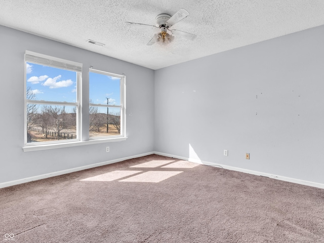 unfurnished room with carpet, visible vents, ceiling fan, and baseboards