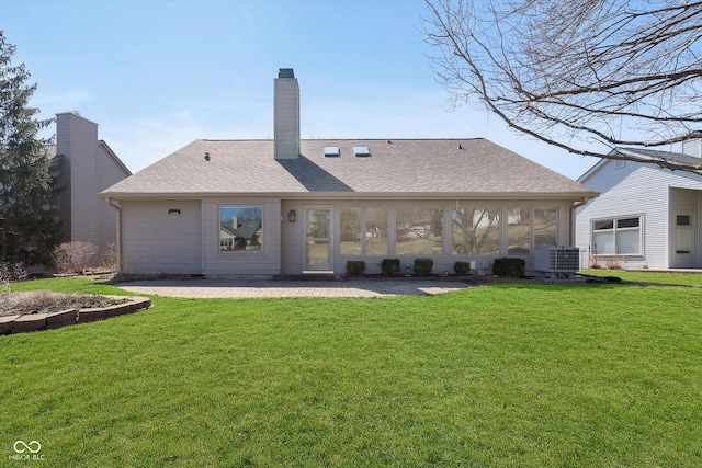 rear view of property featuring a patio, a lawn, and roof with shingles