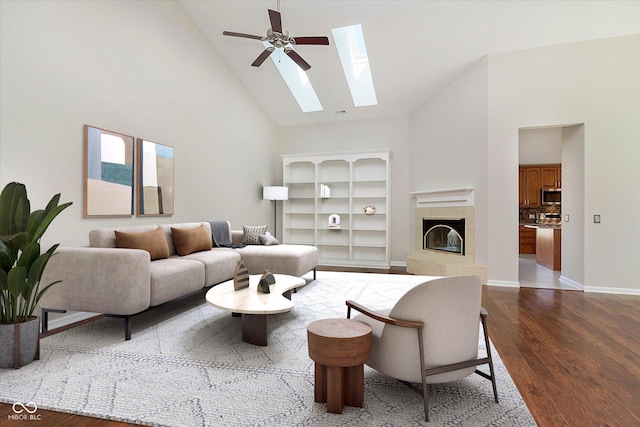 living area featuring high vaulted ceiling, a fireplace, a skylight, and dark wood-style flooring