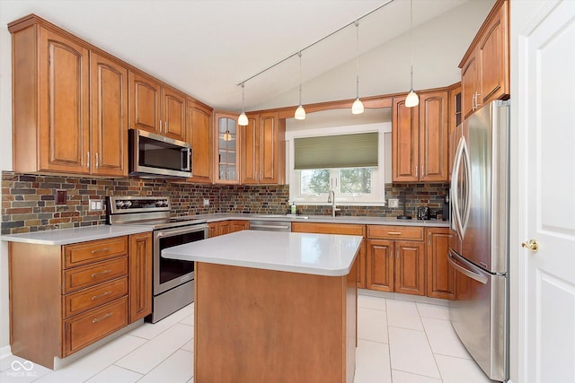 kitchen with glass insert cabinets, vaulted ceiling, decorative backsplash, brown cabinets, and appliances with stainless steel finishes