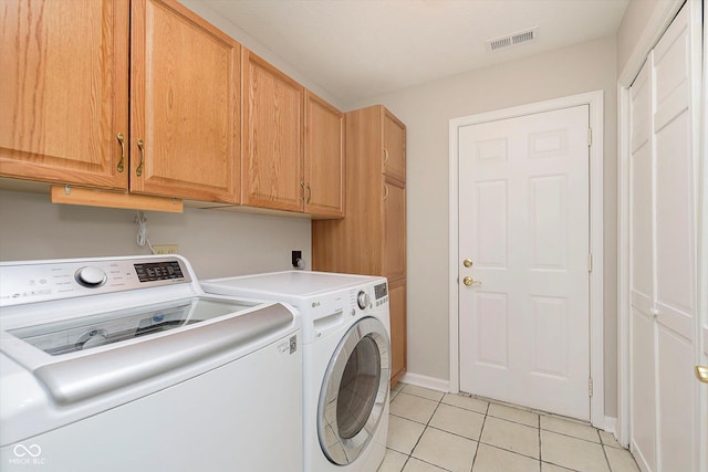 laundry area with light tile patterned flooring, visible vents, cabinet space, and washing machine and dryer