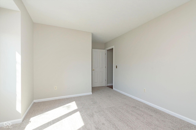 carpeted empty room featuring baseboards