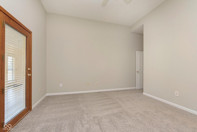 spare room featuring baseboards, light carpet, and a ceiling fan