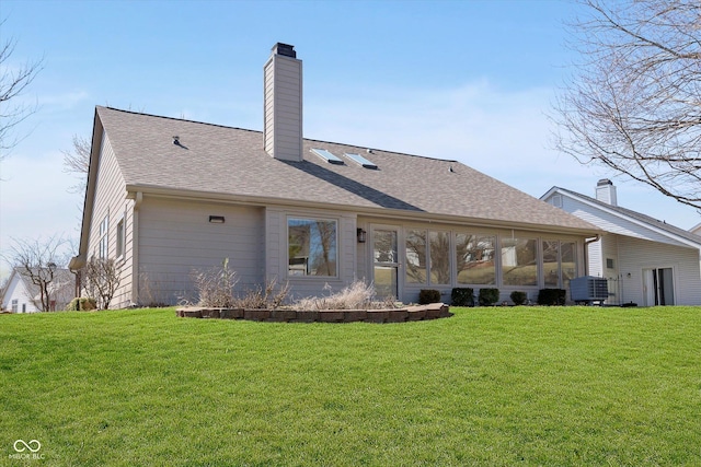 back of house featuring cooling unit, a lawn, a chimney, and a shingled roof