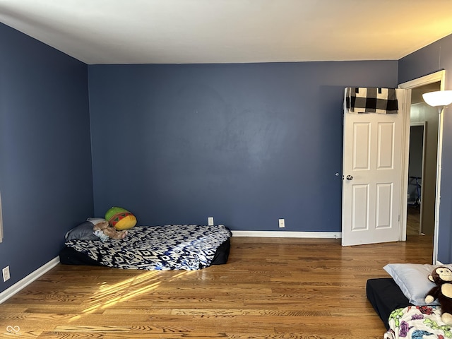 bedroom featuring baseboards and wood finished floors