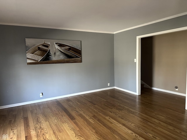 spare room with baseboards, wood finished floors, and crown molding