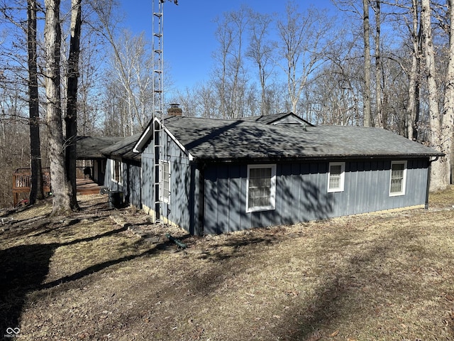 view of property exterior featuring a shingled roof and a chimney