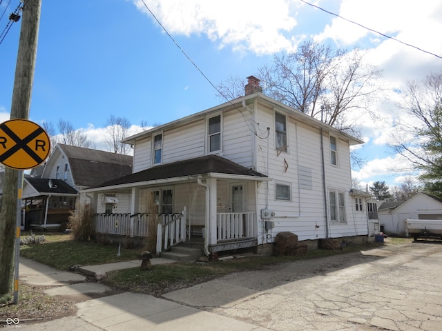 view of front of property with a chimney and a porch