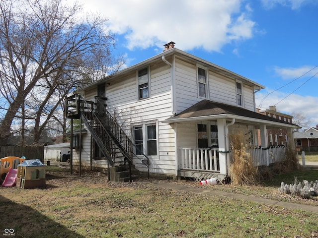 exterior space featuring covered porch, a chimney, and stairway