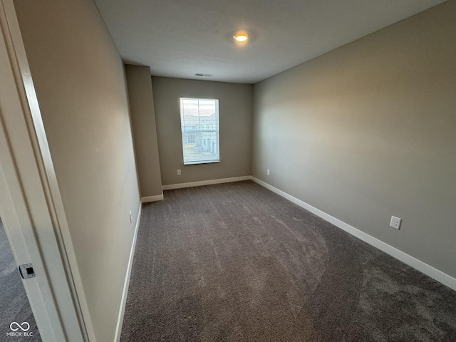 carpeted spare room featuring baseboards