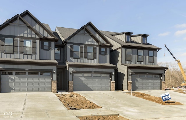 view of property with brick siding, a shingled roof, concrete driveway, an attached garage, and board and batten siding