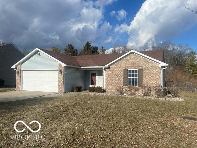 single story home with a garage, concrete driveway, brick siding, and a front yard