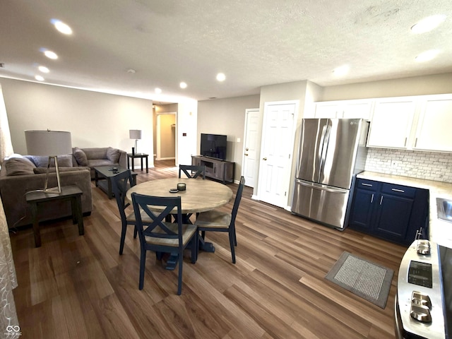 dining room with a textured ceiling, dark wood-style flooring, and recessed lighting