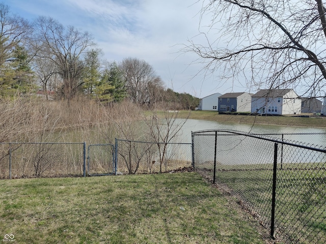 view of yard with a water view, a gate, and fence