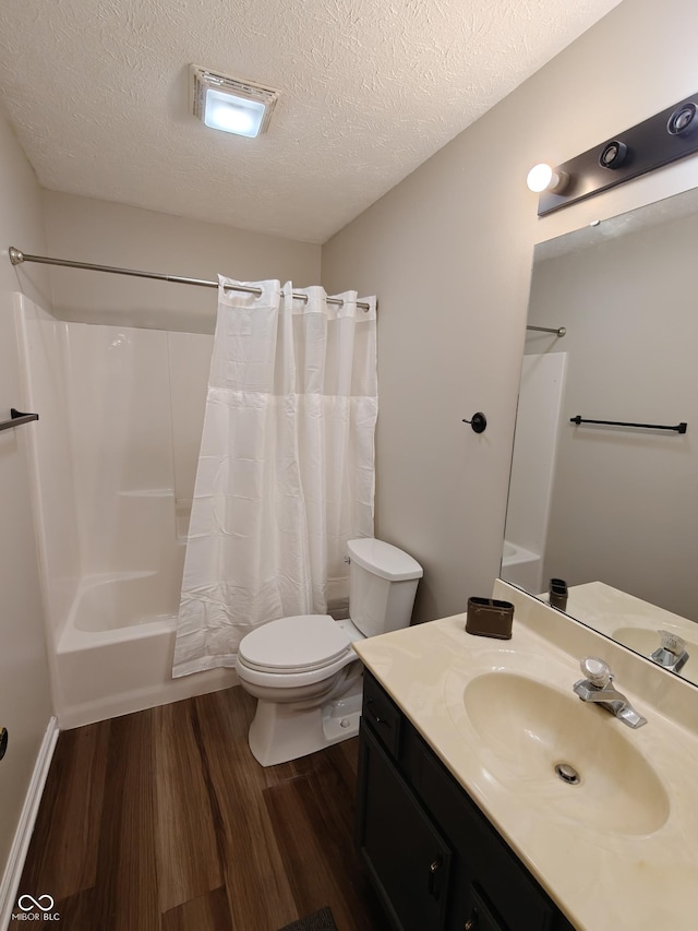 full bath with shower / bath combination with curtain, toilet, vanity, a textured ceiling, and wood finished floors