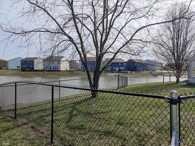 view of yard with a water view, a residential view, and fence